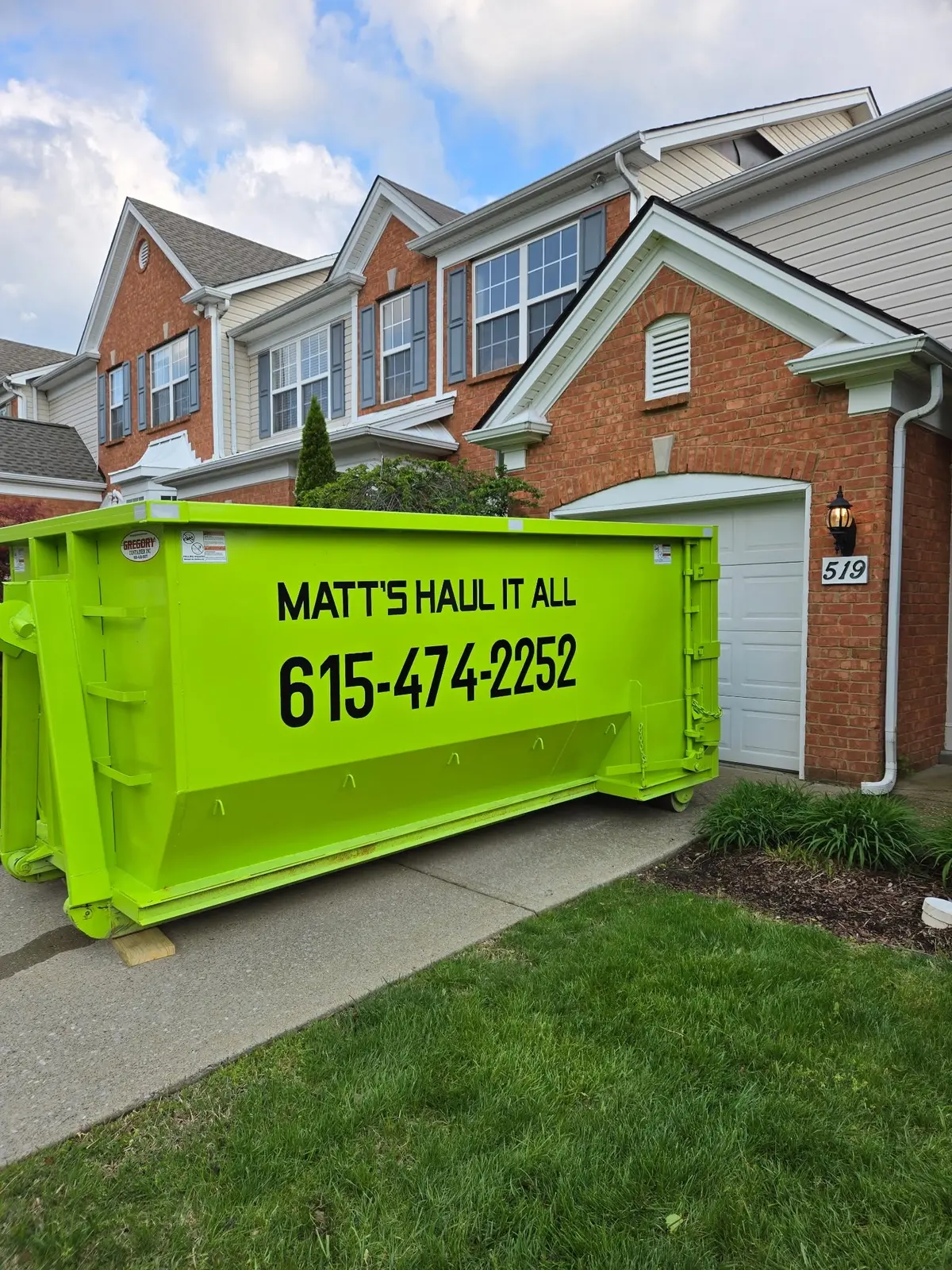 Lime green dumpster on a driveway in Spring Hill, TN